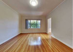 A clean, retro two-bedroom, one bath house with carport, small fenced