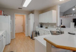 Moving into the kitchen you will find white cabinets, LVT flooring.
