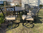 Like NEW- Cast aluminum 9 piece outdoor dining table, 8 swivel chairs w cushions