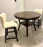 round wooden table and two swivel chairs