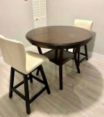 round wooden table and two swivel chairs