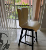 round wooden table and two swivel chairs