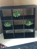 Cubby bookshelf; black coffee table; brown coffee table