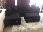 black linen Sectional Sofa with ottoman and 2 accent pillows.