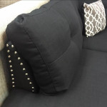 black linen Sectional Sofa with ottoman and 2 accent pillows.