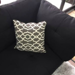 black linen Sectional Sofa with ottoman and 2 accent pillows.