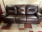 Leather sofa with built-in footrest in good condition.