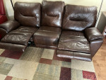 Leather sofa with built-in footrest in good condition.