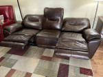 Leather sofa with built-in footrest in good condition.