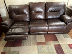 Leather sofa with built-in footrest in good condition.