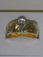 One 14 karat yellow gold ring with flush setting pear shaped diamond